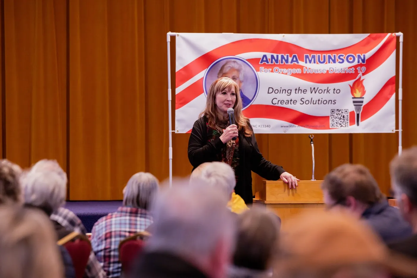 Senator Kim Thatcher speaking at an Anna Munson event in front of the campaign banner